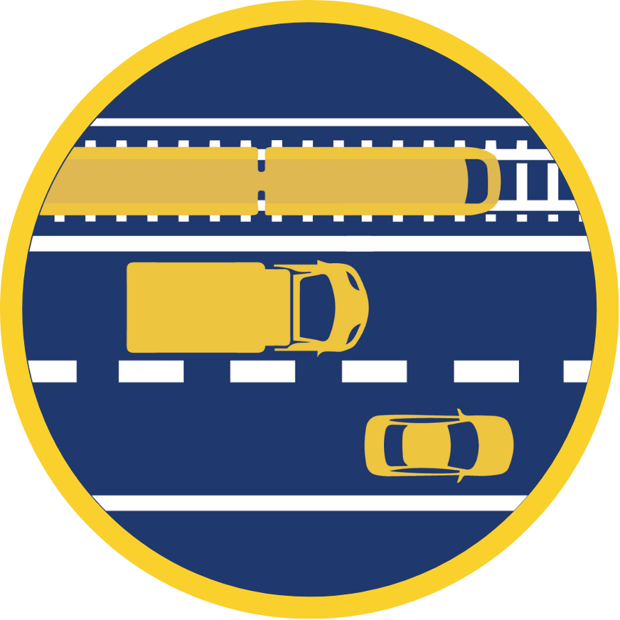 A traffic corridor with a rail line and two vehicle lanes viewed from above